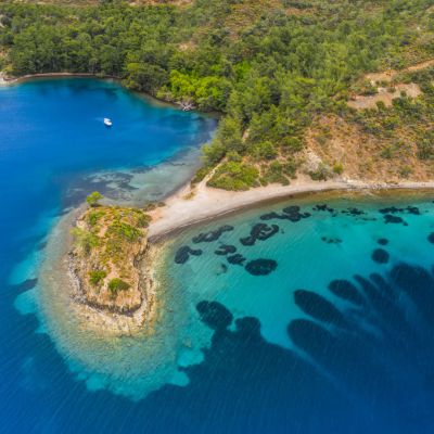 Aerial view of clear turquoise water near the rocky coast of the Aegean Sea, Turkey.